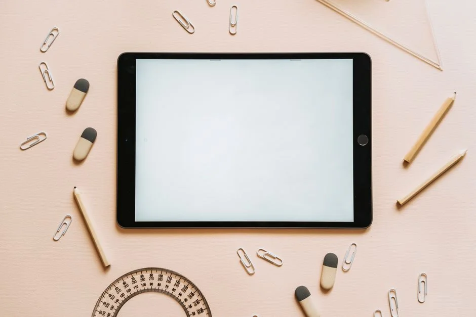 A tablet with a financial website open, alongside a white keyboard and mouse. Ideal for tech-theme stock images.